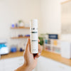 Hand holding a DMK Biogen C product in an esthetician's office.