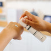 Person holding a DMK product labeled 'BioGen C' in an esthetician's office.