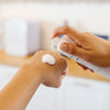 Person applying a dollop of mousse to their hand using a container of Skin Mousse CO2 Lift