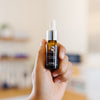 Hand holding a iS Clinical Super Serum Advance+ bottle in an esthetician's office.