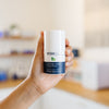 Hand holding a WISH Skin Health Ultimate Detox Clay Mask bottle in an estheticians office