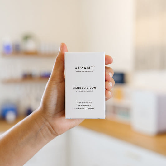 Hand holding a Vivant skincare mini duo product box in an estheticians office