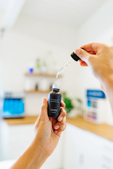 Person using a dropper to add liquid from a Vivant bottle into another container.